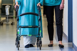Staff assisting patient with walking
